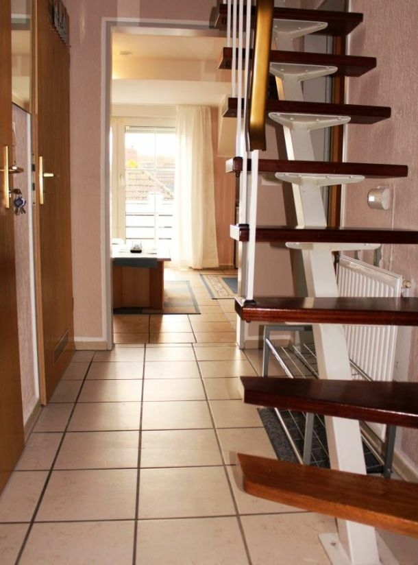 Ferienwohnung Tag am Strand – großer Flur mit Treppe zum Dachstudio