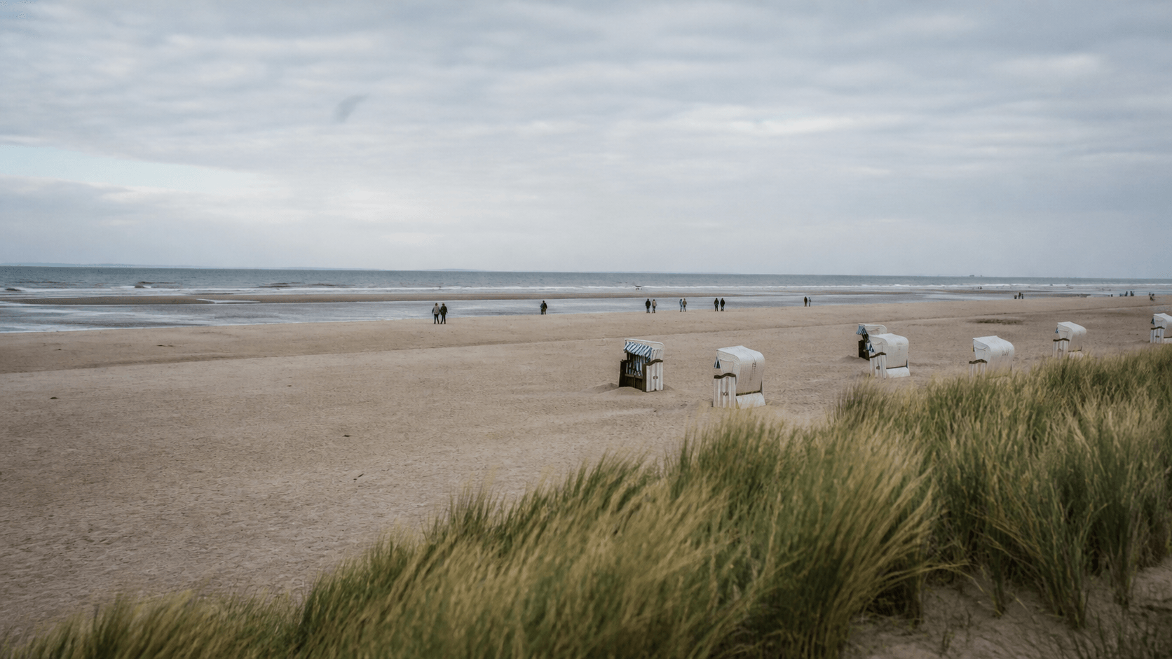 Dünenlandschaft an der ostfriesischen Nordseeküste unter sanft bewölktem Himmel